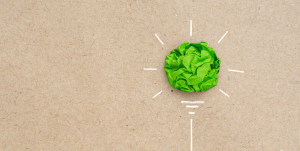 Green crumpled paper on a brown paper background made to look like a lightbulb.