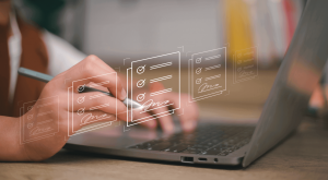 A woman on a laptop with symbols representing an electronic signature overlaying the image.