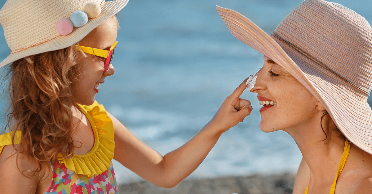 child applying suncream to mothers face