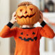 Image of a child playing with pumpkin at home.