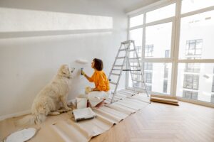 A woman renovating a home with a golden retriever sat next to her.