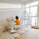 A woman renovating a home with a golden retriever sat next to her.