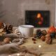 An image of a wooden table with pinecones, conkers, leaves and pumpkins scattered across it.