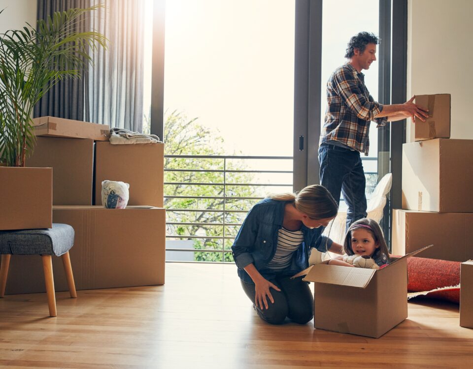 A family including two parents and a child packing boxes because they are moving to Reading.