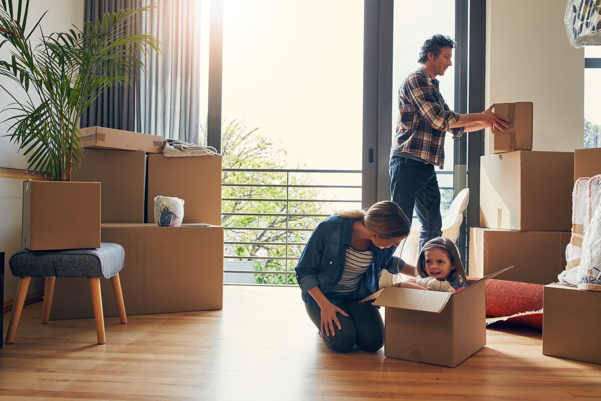 A family including two parents and a child packing boxes because they are moving to Reading.