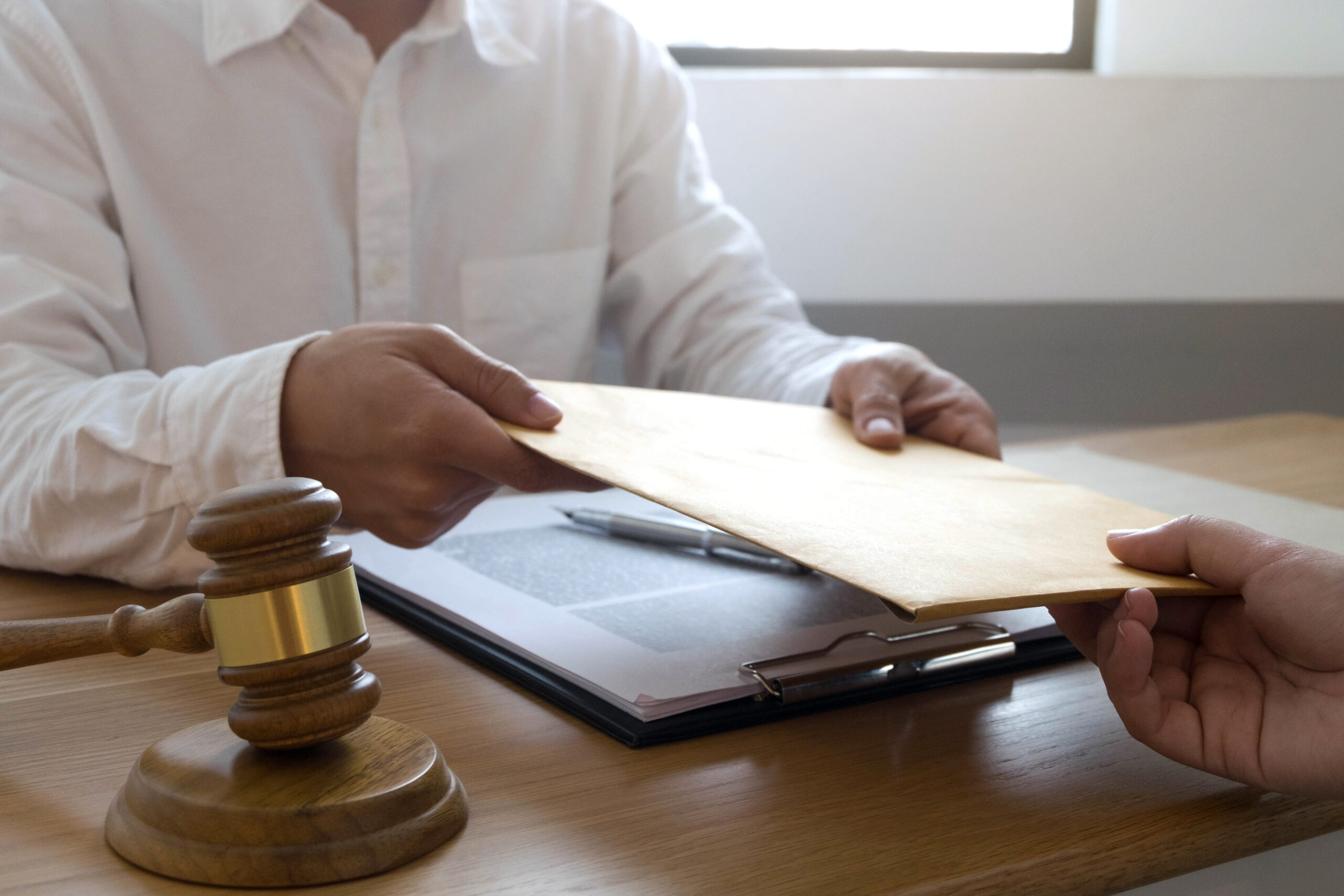 An image of a lawyer giving a divorce contract to someone regarding splitting assets.