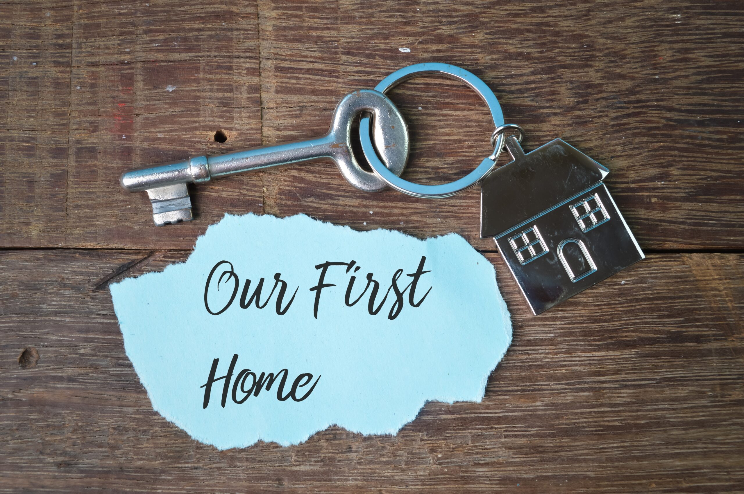 An image of a first home keyring with a house pendant on it on a table.