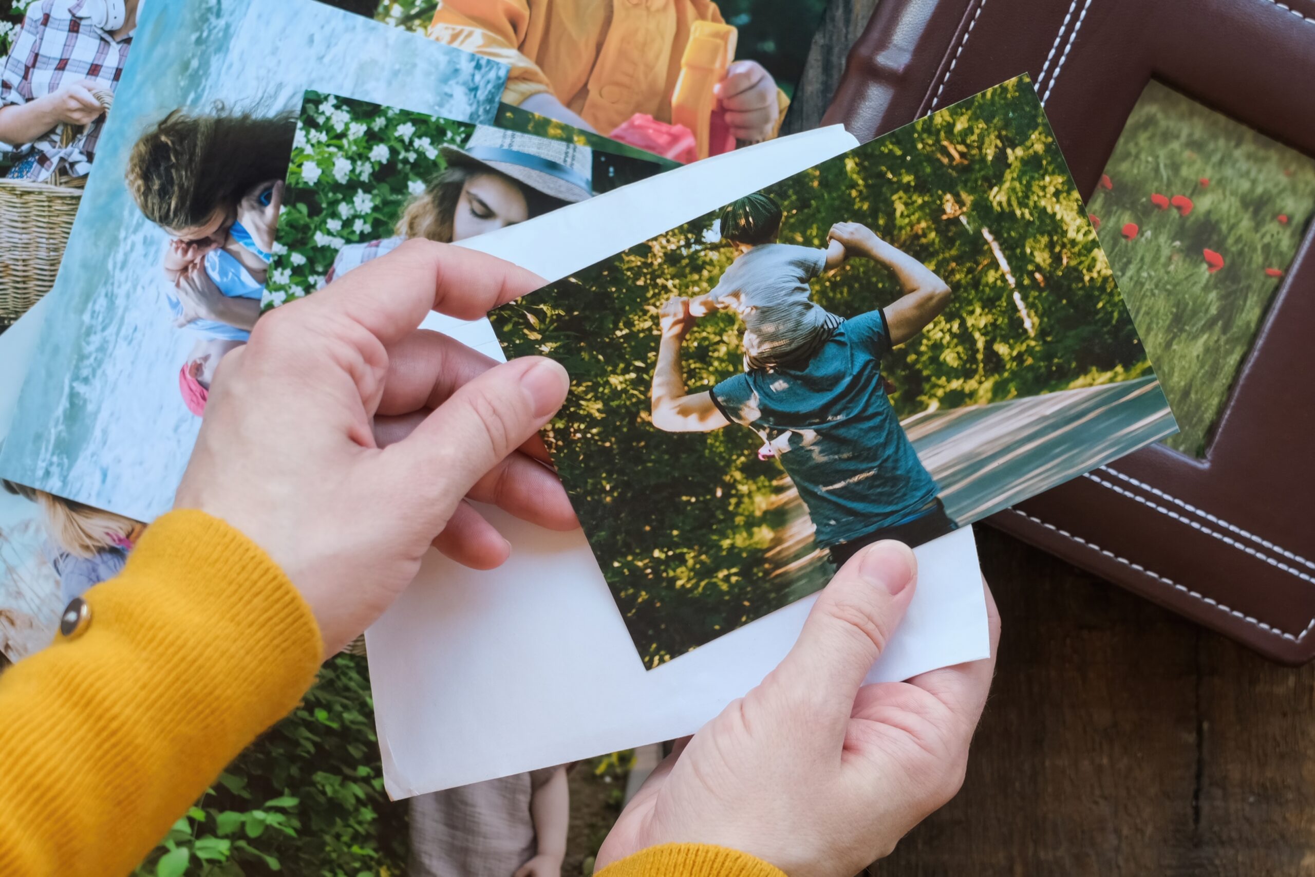 An image of someone holding a collection of photographs.