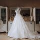 An image of a wedding dress on a mannequin in someones bedroom.