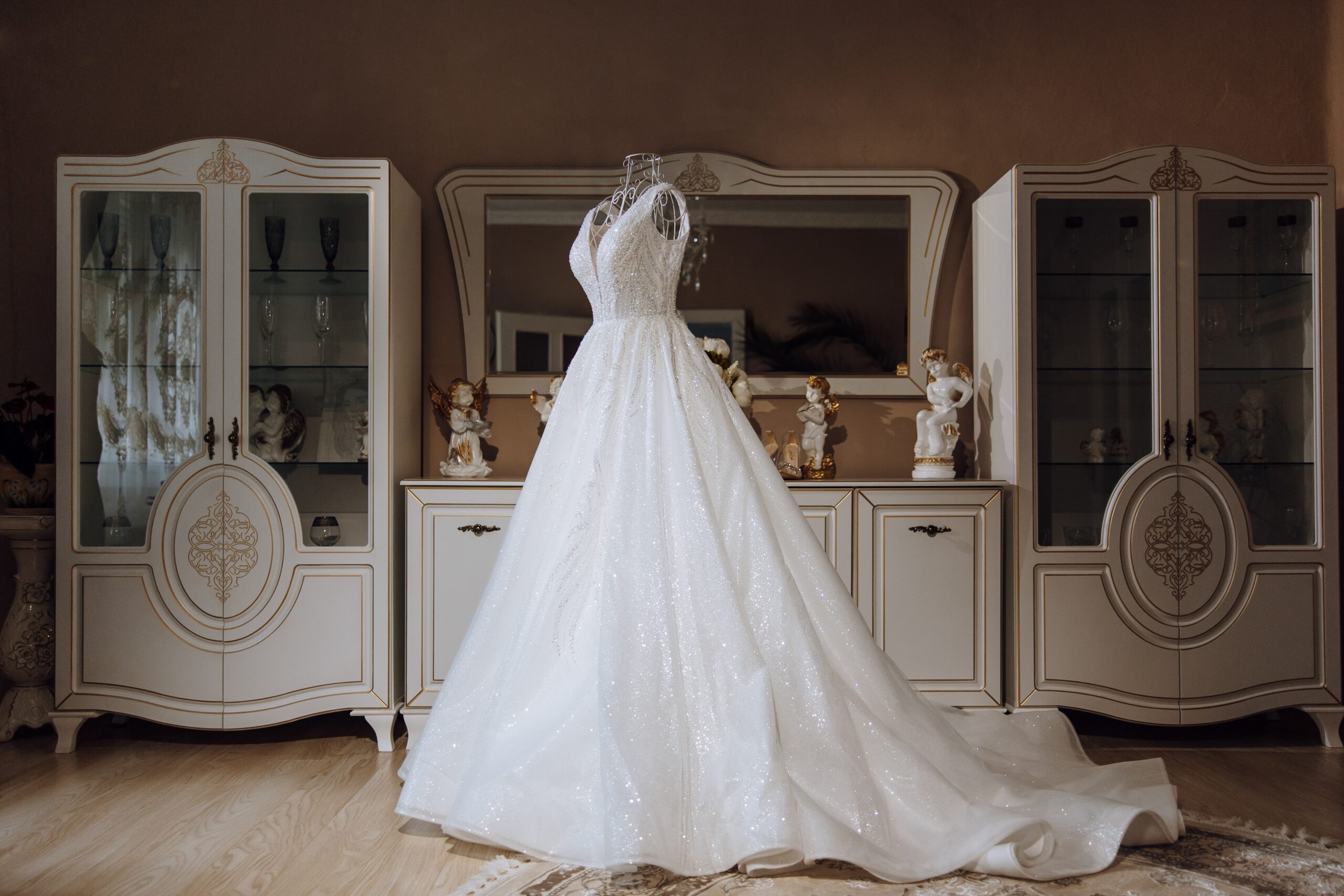 An image of a wedding dress on a mannequin in someones bedroom.