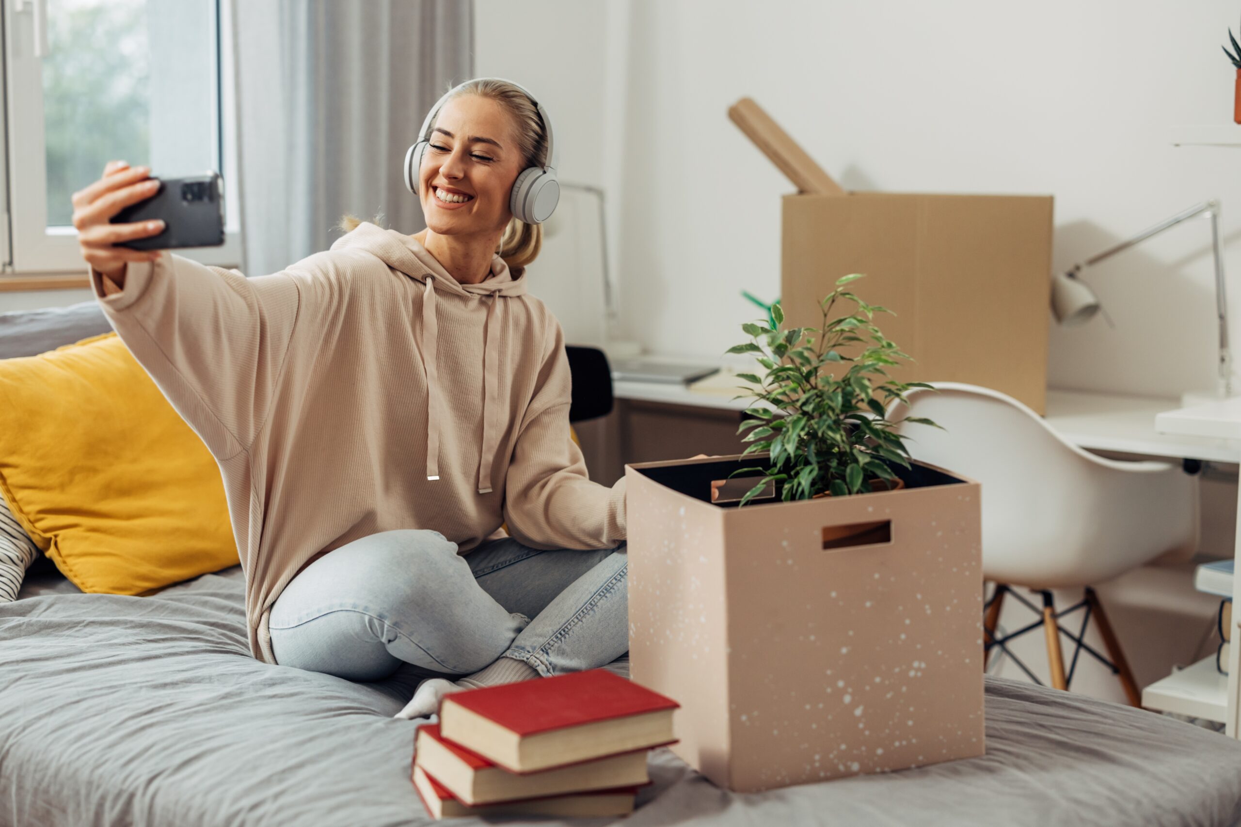 A student taking a selfie on her bed while moving away from home to university.