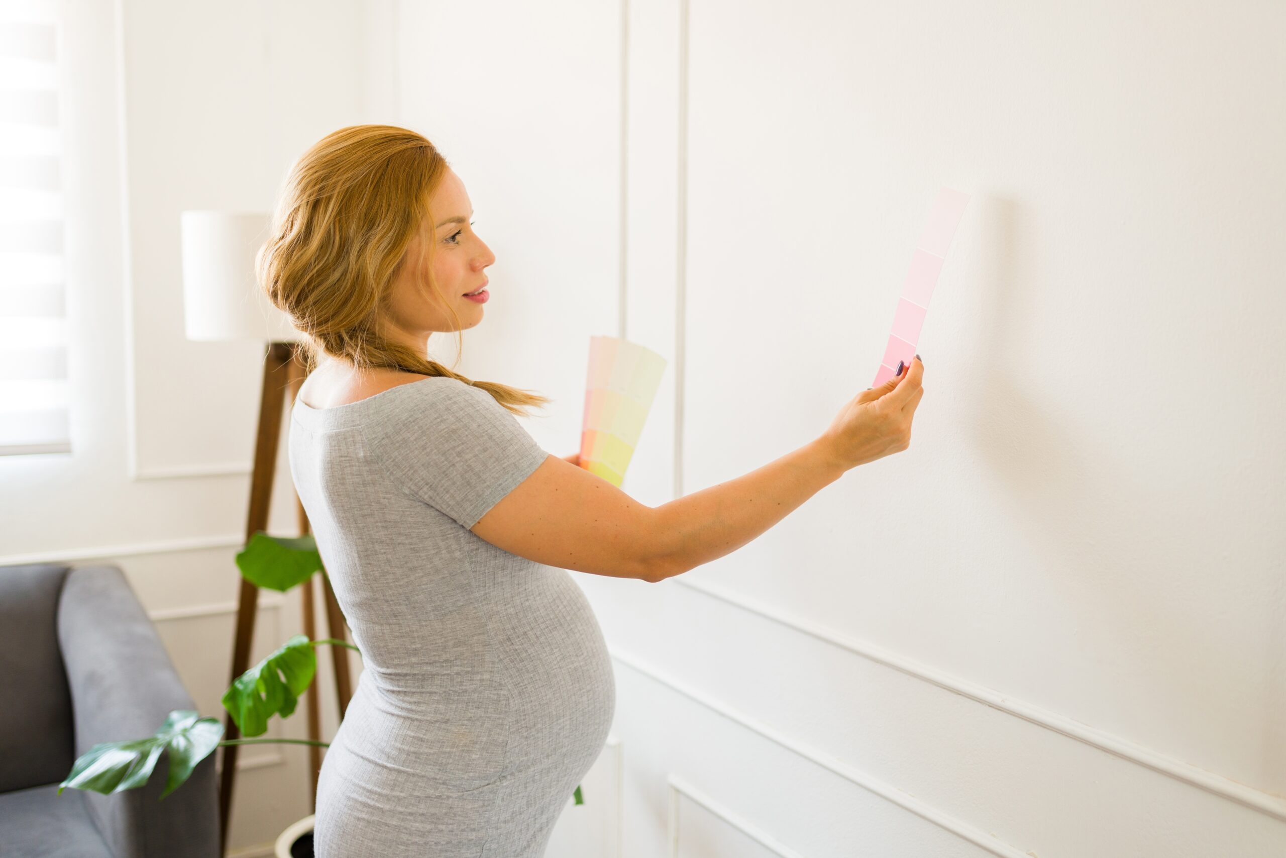 An image of a pregnant woman decorating a nursery.