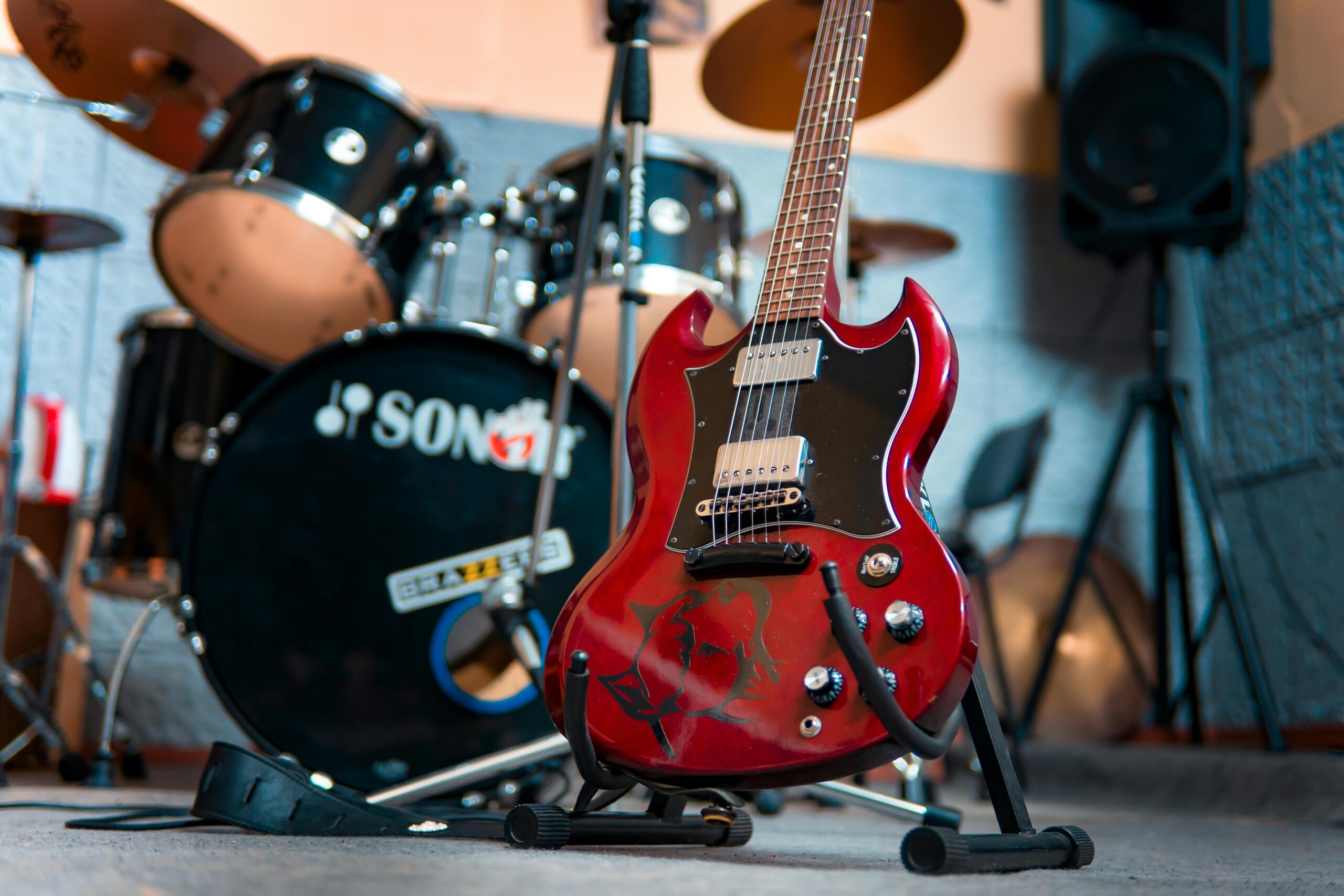 A range of musical instruments including an electric guitar and a drumset.