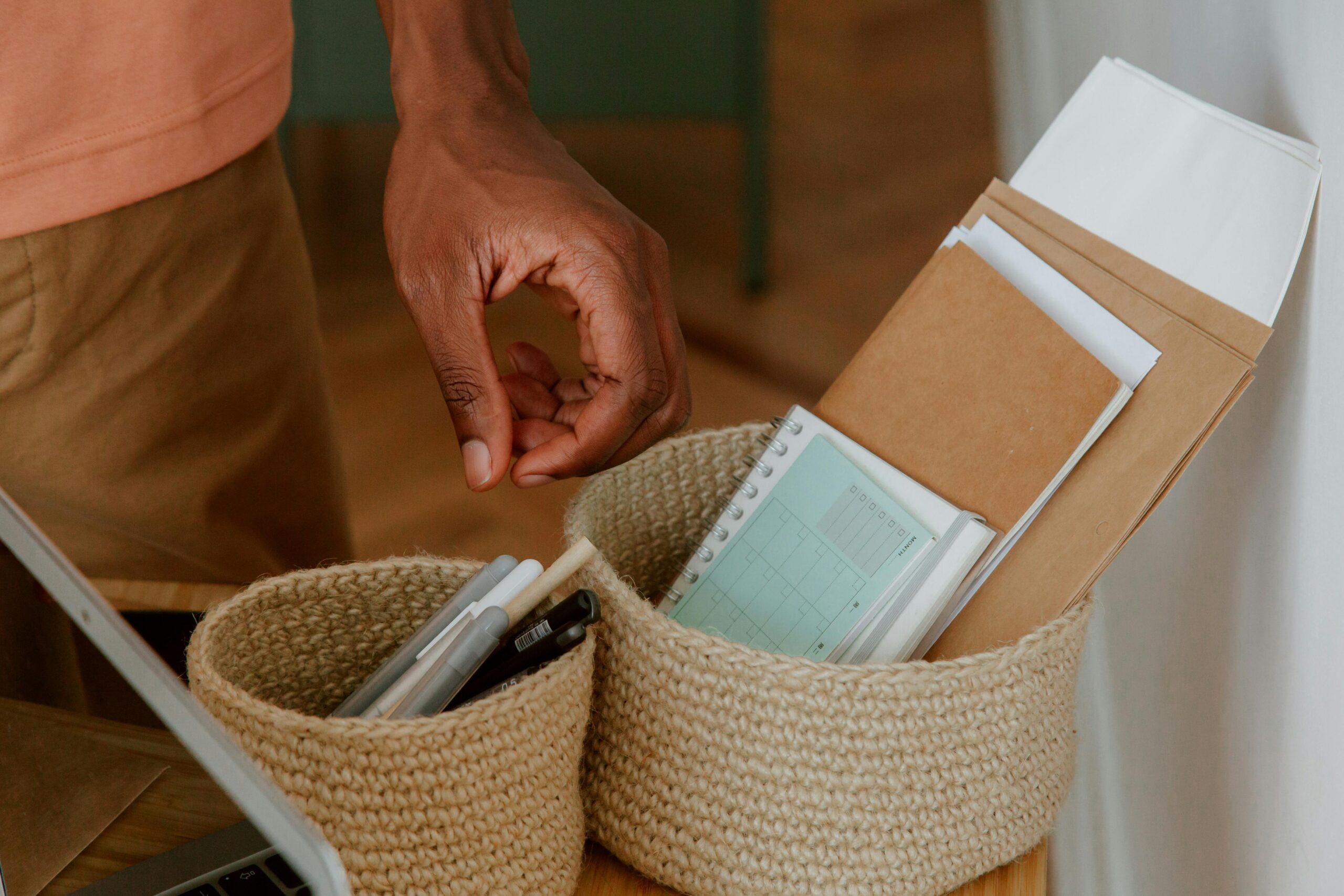home office desk baskets with notebooks in them.